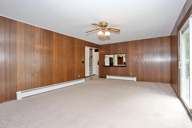 19 Verona Ct, New City, NY 10956 - unfurnished living room with a baseboard radiator, a ceiling fan, light colored carpet, wooden walls, and stairs