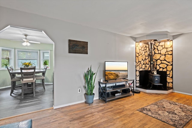 12 Debragga Ave, East Moriches, NY 11940 - living room featuring a wood stove, wood finished floors, baseboards, and a ceiling fan