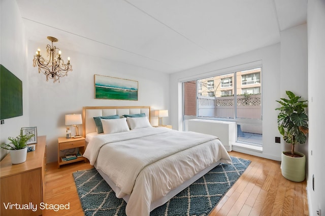 555 W 23rd St Unit S3Q, New York Manhattan, NY 10011 - bedroom featuring light wood-style flooring, a chandelier, and access to outside