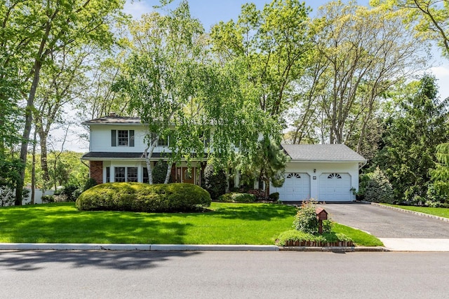 18 Stuyvesant Cir E, East Setauket, NY 11733 - obstructed view of property with driveway, an attached garage, a front yard, and a chimney