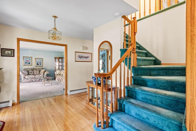 18 Stuyvesant Cir E, East Setauket, NY 11733 - staircase with hardwood / wood-style flooring, a baseboard radiator, and a chandelier
