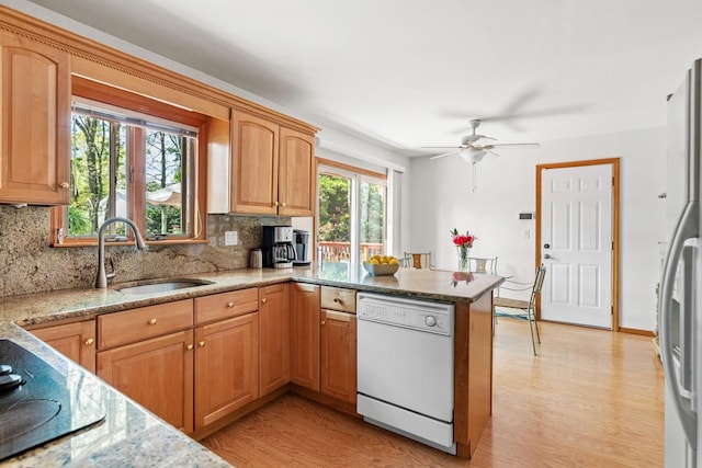 18 Stuyvesant Cir E, East Setauket, NY 11733 - kitchen with dishwasher, a sink, light wood-type flooring, a peninsula, and backsplash