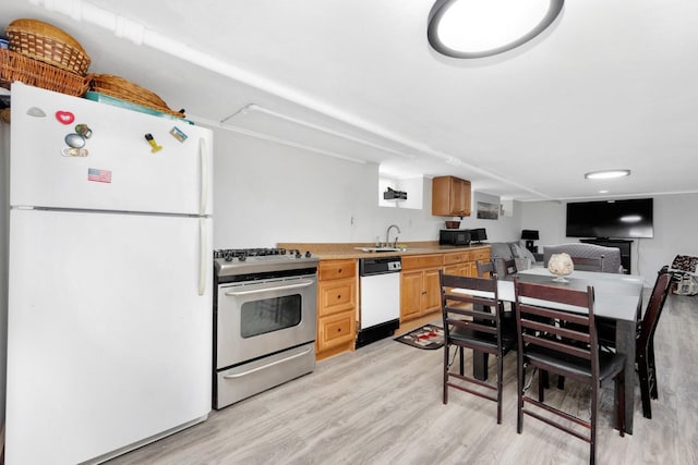 69-59 74th St, Middle Village, NY 11379 - kitchen with white appliances, light wood-style flooring, light countertops, a sink, and light brown cabinetry