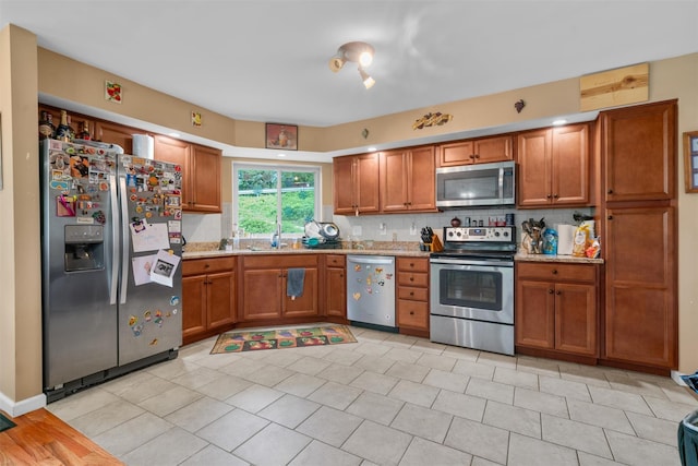 448 Old Mountain Rd, Port Jervis, NY 12771 - kitchen with stainless steel appliances, brown cabinetry, a sink, and tasteful backsplash