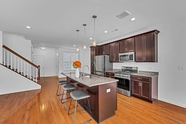 37 Lindentree Ln, Middletown, NY 10940 - kitchen featuring stainless steel appliances, a breakfast bar area, a sink, light wood-type flooring, and light stone countertops