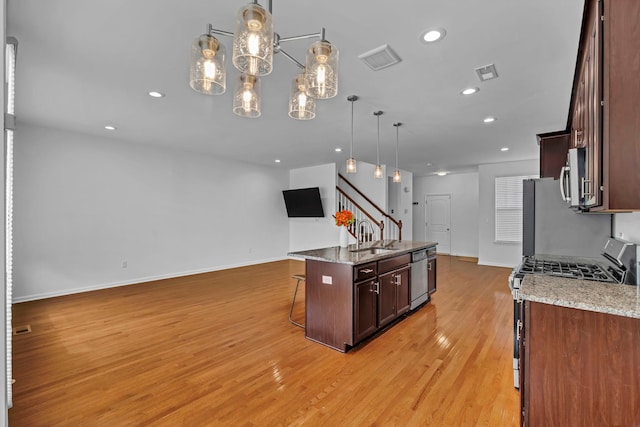 37 Lindentree Ln, Middletown, NY 10940 - kitchen featuring appliances with stainless steel finishes, a kitchen bar, open floor plan, light wood-style flooring, and baseboards