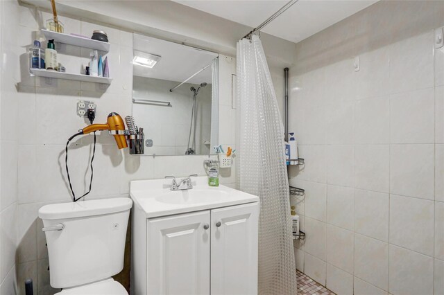 34-08 Murray Ln, Flushing, NY 11354 - full bathroom with vanity, toilet, tiled shower, and tile walls