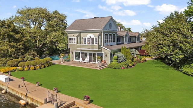 rear view of house with a yard, a patio, an outdoor pool, and a shingled roof