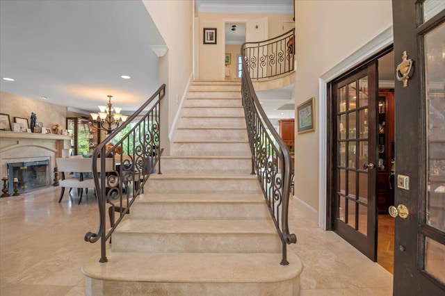 stairway featuring a chandelier, tile patterned flooring, a fireplace, recessed lighting, and baseboards