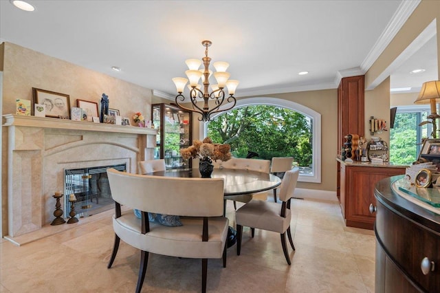 dining room featuring a chandelier, crown molding, a premium fireplace, baseboards, and recessed lighting