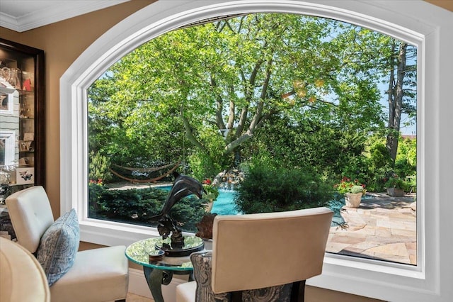 sitting room featuring crown molding and healthy amount of natural light