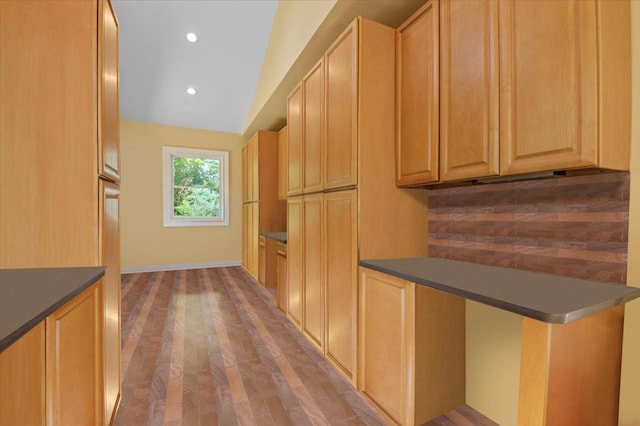 kitchen featuring decorative backsplash, wood finished floors, dark countertops, recessed lighting, and light brown cabinetry