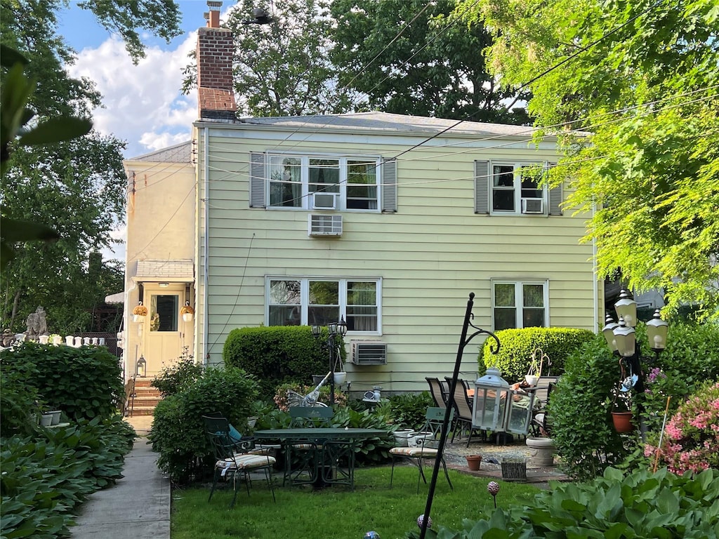 196-19 42nd Rd, Flushing, NY 11358 - rear view of house with a chimney, a wall mounted AC, and a patio area