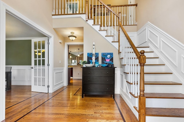 135 Ray Blvd, Poughkeepsie, NY 12603 - stairs with wood finished floors, a decorative wall, wainscoting, and a towering ceiling