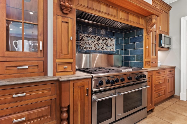 5 Club Way, Mount Kisco, NY 10549 - kitchen featuring appliances with stainless steel finishes, backsplash, brown cabinetry, light tile patterned floors, and glass insert cabinets