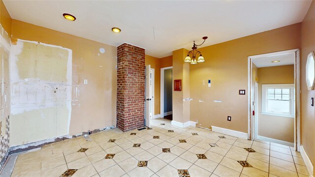 55 Teller Ave, Beacon, NY 12508 - unfurnished room featuring a chandelier, light tile patterned floors, baseboards, and decorative columns