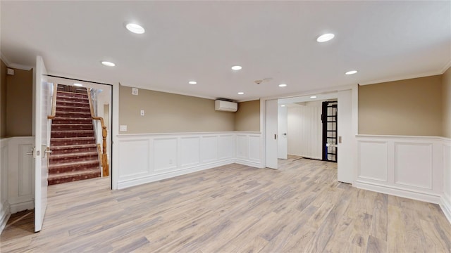 55 Teller Ave, Beacon, NY 12508 - spare room with a decorative wall, wainscoting, a wall mounted air conditioner, stairs, and light wood-type flooring