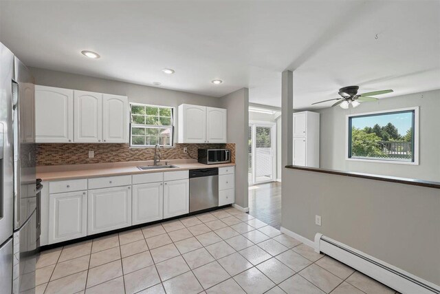 54 Capital Dr, Washingtonville, NY 10992 - kitchen with appliances with stainless steel finishes, baseboard heating, a sink, decorative backsplash, and white cabinets