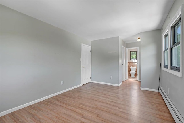 54 Capital Dr, Washingtonville, NY 10992 - empty room featuring a baseboard heating unit, light wood-style floors, and baseboards