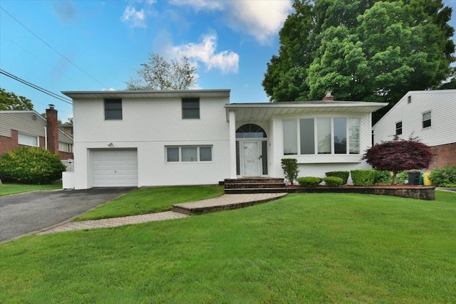 10 Linda Ln, Plainview, NY 11803 - view of front of house with an attached garage, asphalt driveway, a front lawn, and a chimney