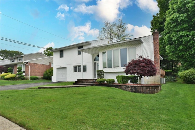 10 Linda Ln, Plainview, NY 11803 - tri-level home featuring asphalt driveway, an attached garage, a chimney, a front lawn, and central air condition unit