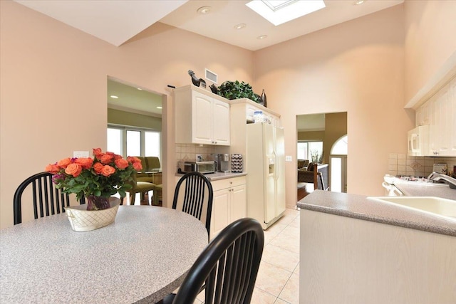 10 Linda Ln, Plainview, NY 11803 - dining room with light tile patterned flooring, a skylight, recessed lighting, and a towering ceiling