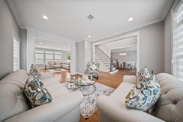 1427 Bellmore Rd, North Bellmore, NY 11710 - living room featuring wood finished floors, ornamental molding, stairs, a chandelier, and recessed lighting