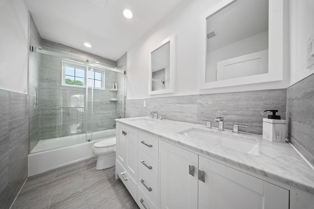 1427 Bellmore Rd, North Bellmore, NY 11710 - bathroom with tile walls, double vanity, toilet, and enclosed tub / shower combo