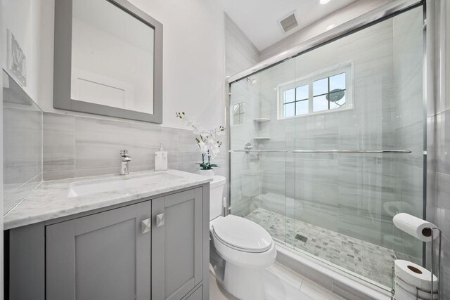 1427 Bellmore Rd, North Bellmore, NY 11710 - full bath with toilet, a shower stall, vanity, tile walls, and backsplash