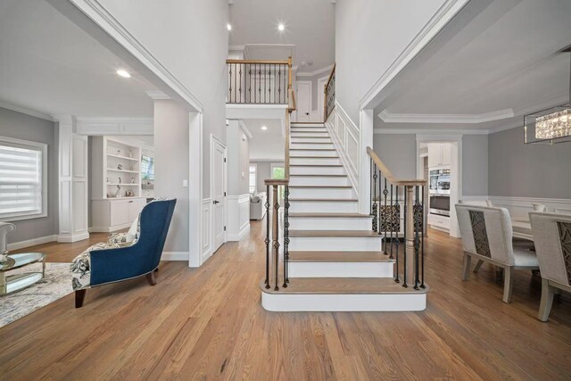 1427 Bellmore Rd, North Bellmore, NY 11710 - stairway with crown molding, wood finished floors, recessed lighting, wainscoting, and a decorative wall