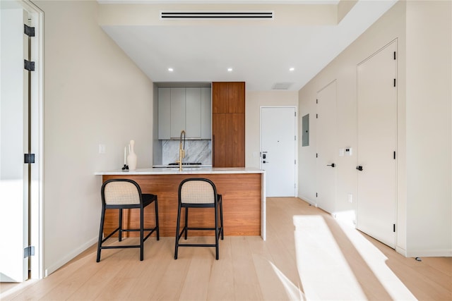 3116 21st St Unit Ph2B, Astoria, NY 11106 - kitchen featuring decorative backsplash, electric panel, a peninsula, gray cabinetry, and recessed lighting