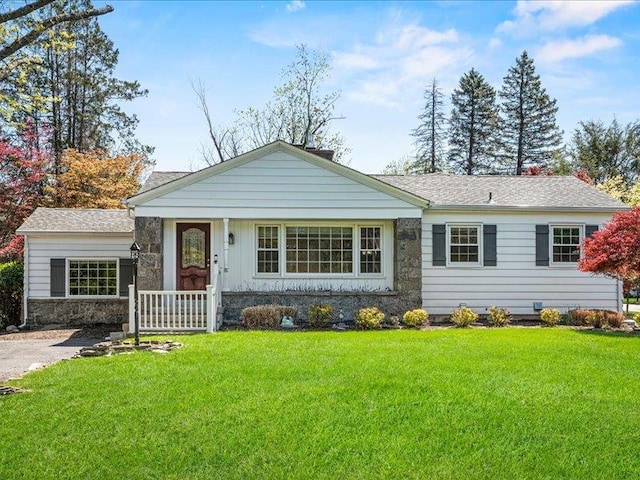 ranch-style house with a front lawn, a porch, and roof with shingles