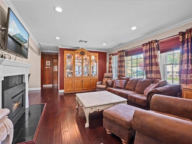 living area with ornamental molding, baseboards, recessed lighting, dark wood-type flooring, and a glass covered fireplace