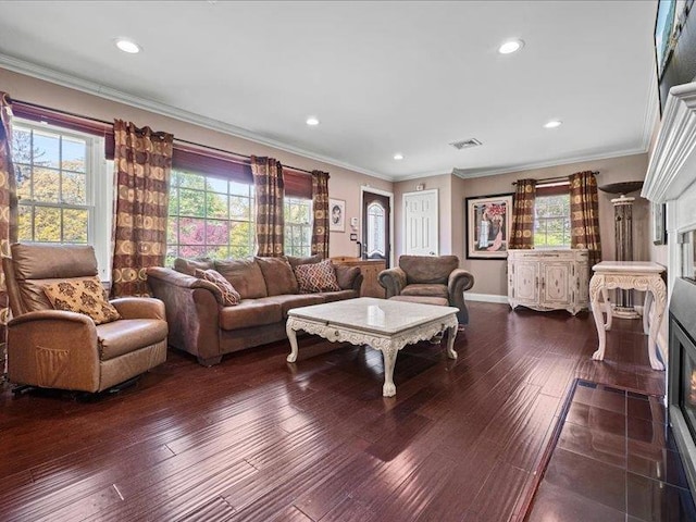 living room featuring a fireplace with flush hearth, dark wood-style flooring, baseboards, crown molding, and recessed lighting