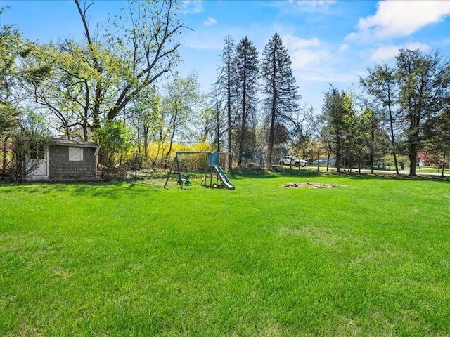 view of grassy yard featuring an outdoor structure and a playground