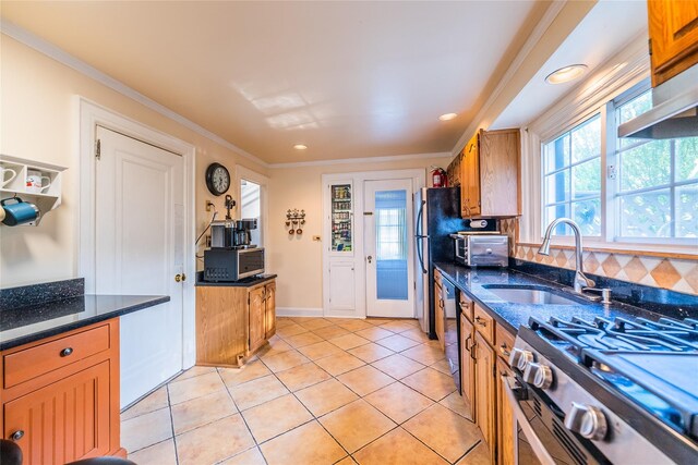 5 Cary Rd, Great Neck, NY 11021 - kitchen with stainless steel appliances, a sink, brown cabinetry, light tile patterned floors, and dark stone countertops