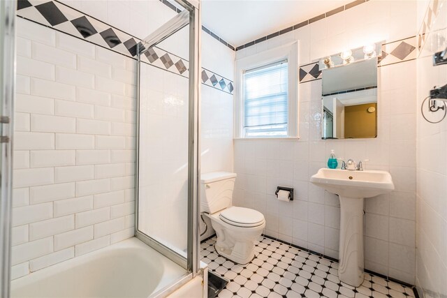 5 Cary Rd, Great Neck, NY 11021 - bathroom with tile walls, toilet, shower / bath combination with glass door, and a sink