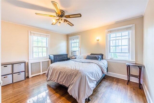 5 Cary Rd, Great Neck, NY 11021 - bedroom featuring radiator heating unit, wood finished floors, baseboards, crown molding, and ceiling fan