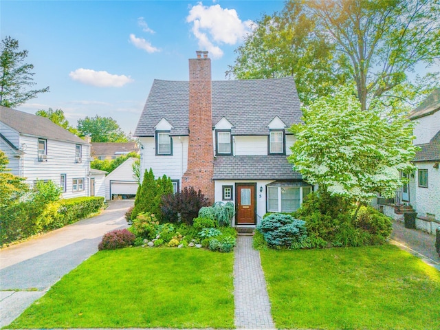 5 Cary Rd, Great Neck, NY 11021 - view of front of property featuring a chimney, a front lawn, a high end roof, and a garage