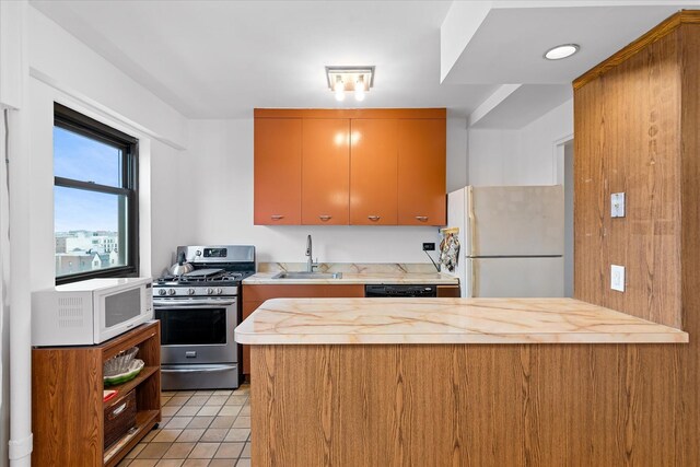 21-50 33rd Rd Unit 12Ab, Astoria, NY 11106 - kitchen with white appliances, a sink, a peninsula, light tile patterned floors, and wooden counters