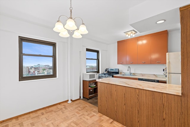 21-50 33rd Rd Unit 12Ab, Astoria, NY 11106 - kitchen with a sink, white appliances, a chandelier, light countertops, and a peninsula
