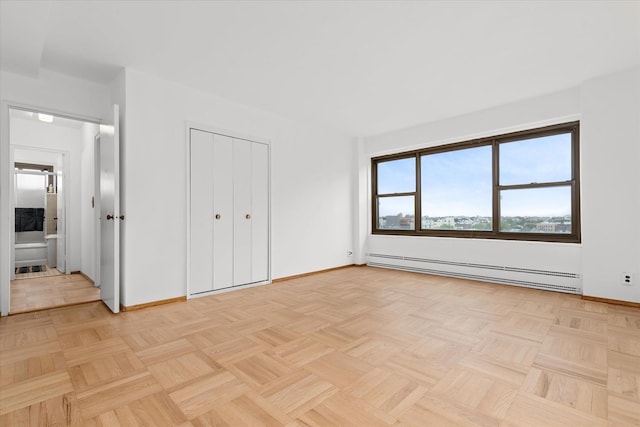 21-50 33rd Rd Unit 12Ab, Astoria, NY 11106 - unfurnished bedroom featuring baseboard heating, baseboards, and a closet