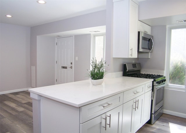 7 Laramie Ct Unit 7, Coram, NY 11727 - kitchen with stainless steel appliances, wood finished floors, white cabinets, healthy amount of natural light, and recessed lighting