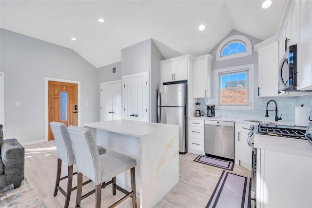 68 Brookline Ave, East Atlantic Beach, NY 11561 - kitchen with stainless steel appliances, lofted ceiling, a sink, a breakfast bar area, and a kitchen island