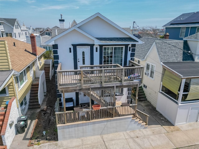 68 Brookline Ave, East Atlantic Beach, NY 11561 - view of front of property featuring stairs, a deck, a residential view, stucco siding, and a patio area