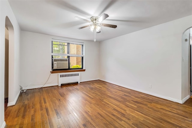 22-39 78th St Unit 2F, East Elmhurst, NY 11370 - spare room featuring radiator, arched walkways, hardwood / wood-style flooring, a ceiling fan, and baseboards