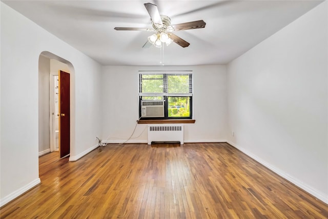 22-39 78th St Unit 2F, East Elmhurst, NY 11370 - empty room with radiator, arched walkways, hardwood / wood-style floors, a ceiling fan, and baseboards