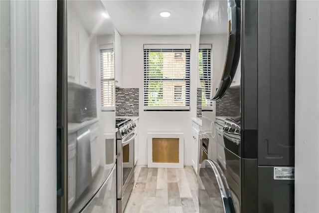 22-39 78th St Unit 2F, East Elmhurst, NY 11370 - kitchen with appliances with stainless steel finishes, backsplash, light wood finished floors, estacked washer and dryer, and recessed lighting