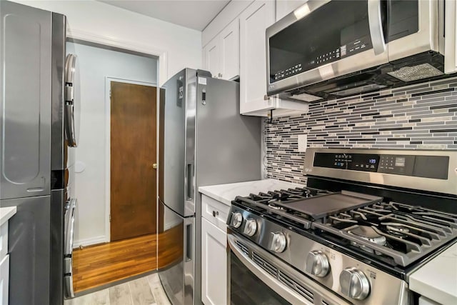 22-39 78th St Unit 2F, East Elmhurst, NY 11370 - kitchen featuring stainless steel appliances, white cabinetry, light wood-style flooring, tasteful backsplash, and light stone counters