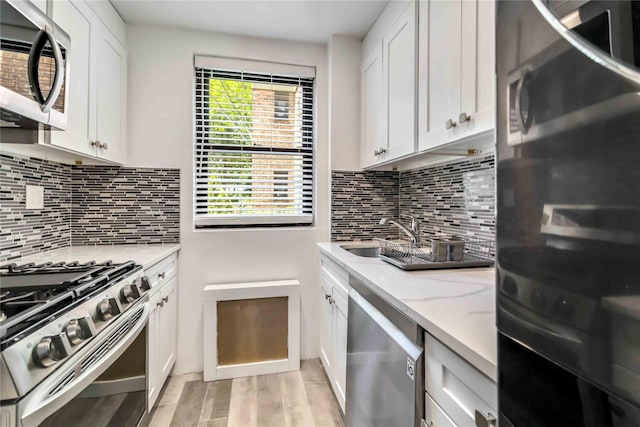 22-39 78th St Unit 2F, East Elmhurst, NY 11370 - kitchen with appliances with stainless steel finishes, a sink, light wood-style floors, and white cabinetry